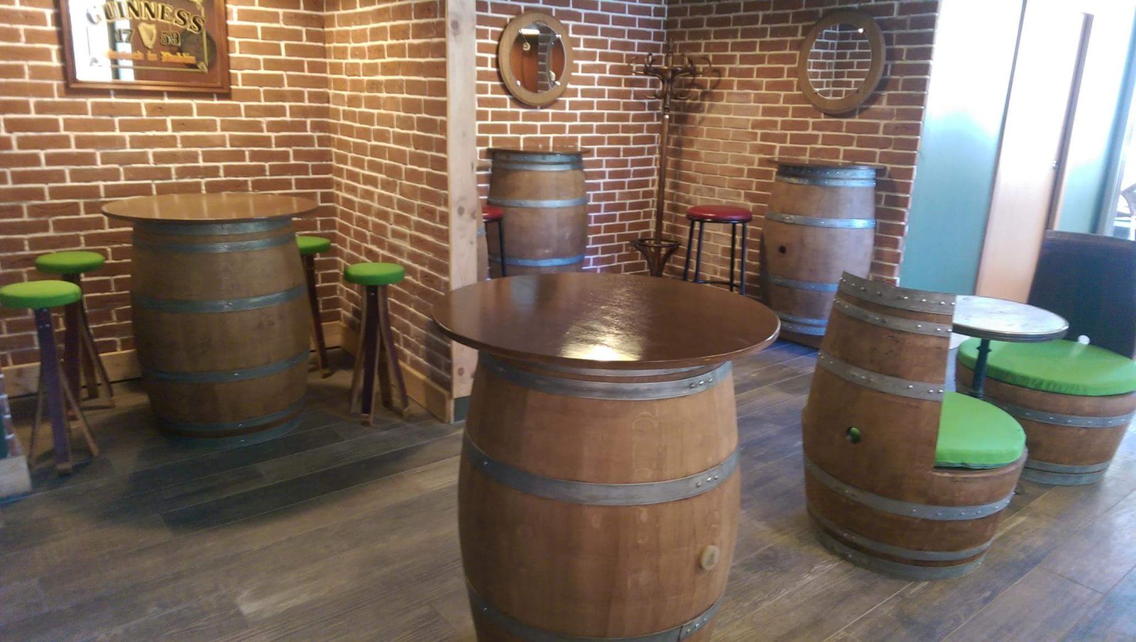 Un espace de bar avec des tables et des chaises en fût de chêne, des murs en briques et un décor chaleureux.