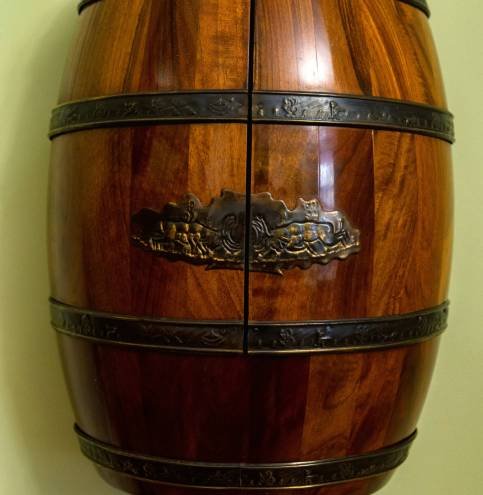 View of renovated old wooden brown barrel View of renovated old wooden brown barrel. Photo made in a museum. Barrel is covered with polish